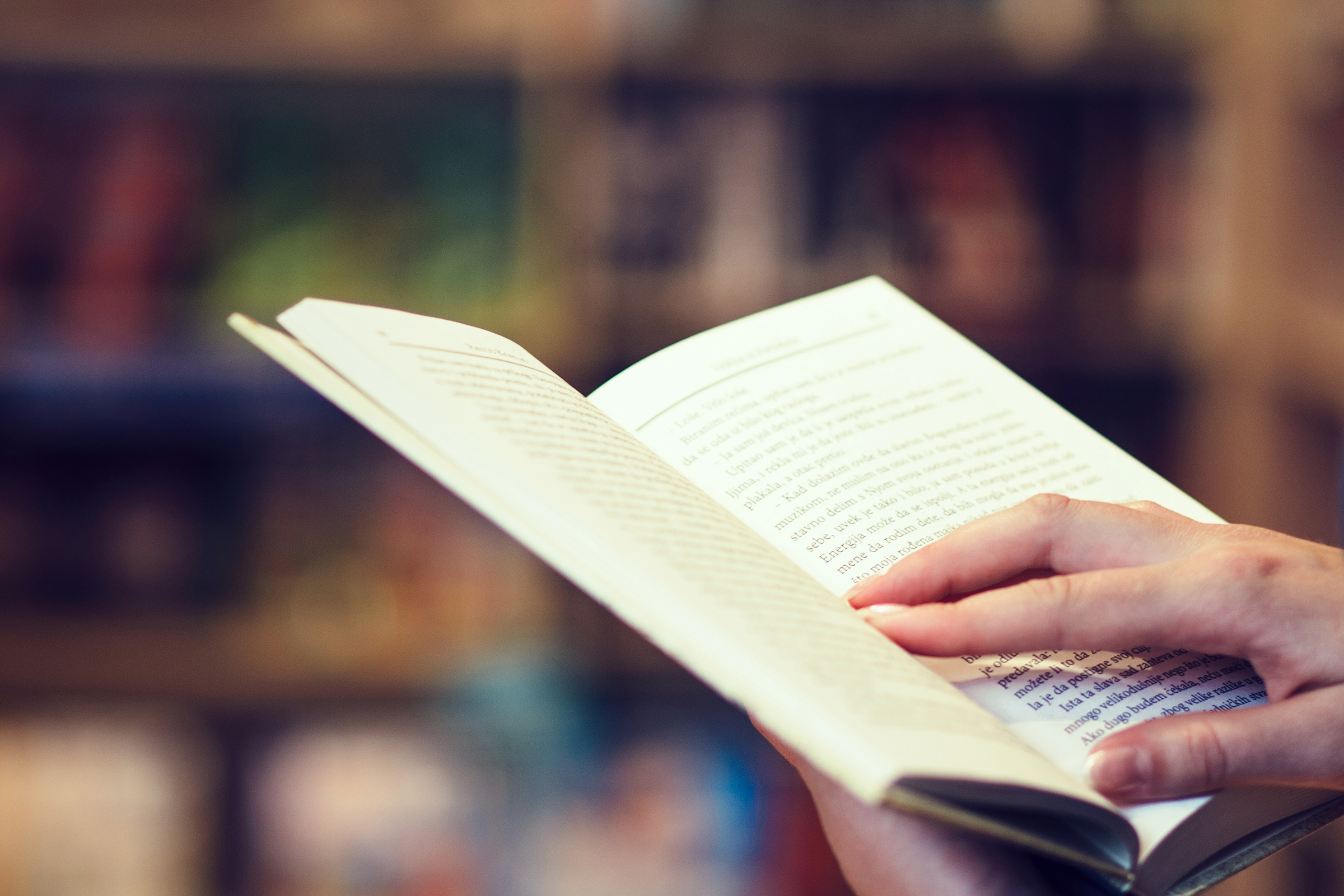 Close up of someone reading a book in a library