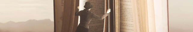 Image of woman standing before an open book