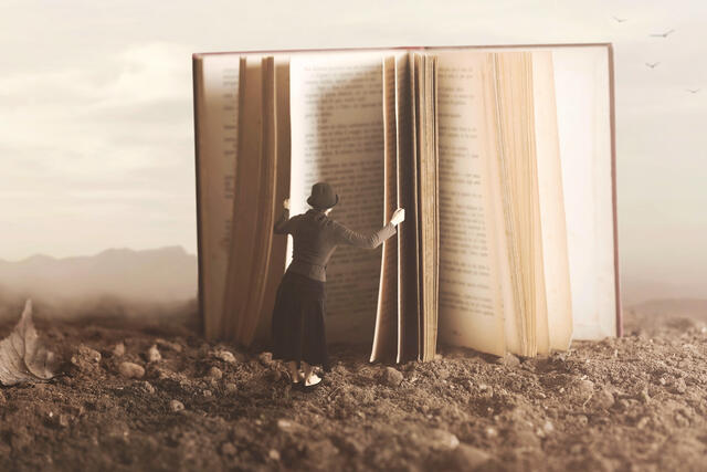 Image of woman standing before an open book